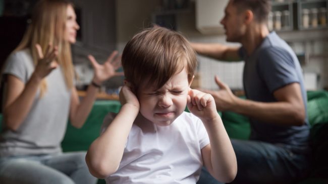 child covering ears during parental conflict