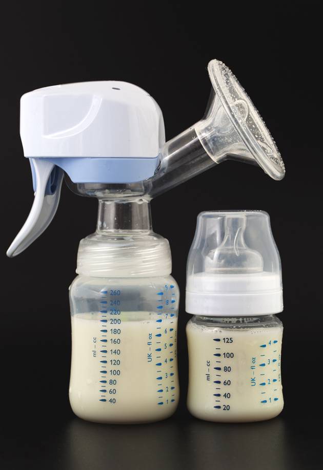 Breast pump attached to bottle