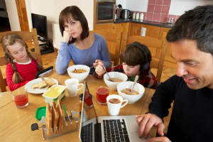 A family glued to their gadgets at breakfast